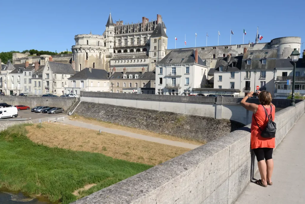 Touriste photographiant le château royal d'Amboise depuis un pont