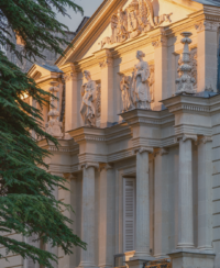 Façade classique française ornée de statues au coucher du soleil